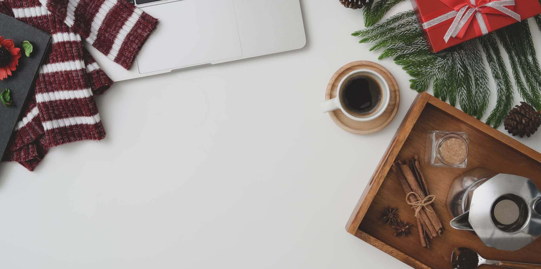 table with laptop near cup of americano and gift box