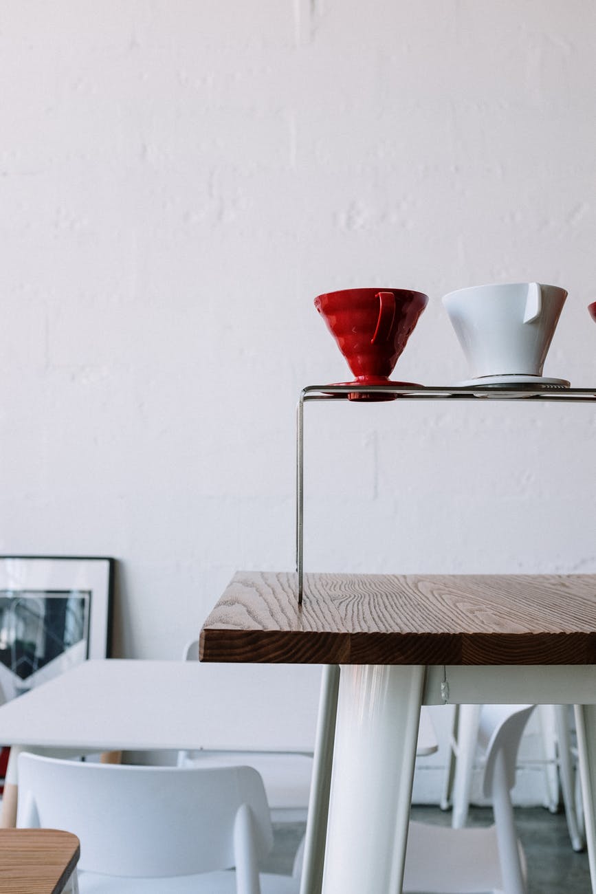 red and white ceramic cup on brown wooden table